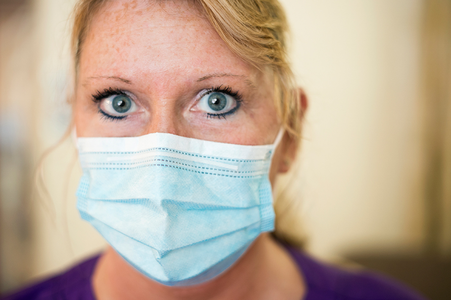 Portrait einer Krankenpflegerin mit Mund-Nasen-Schutz