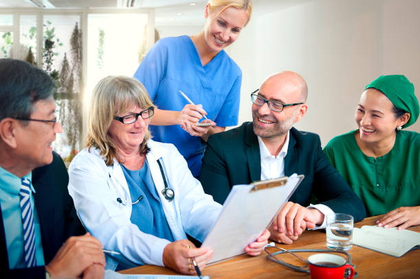 Ein gemischtes Team aus Ärzten, Pflegern und Verwaltung sind mit dem Ergebnis ihres Meetings zufrieden.