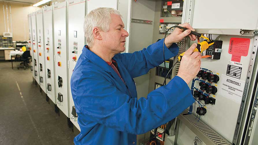 Elektriker bei Prüfarbeiten an einem Schaltschrank