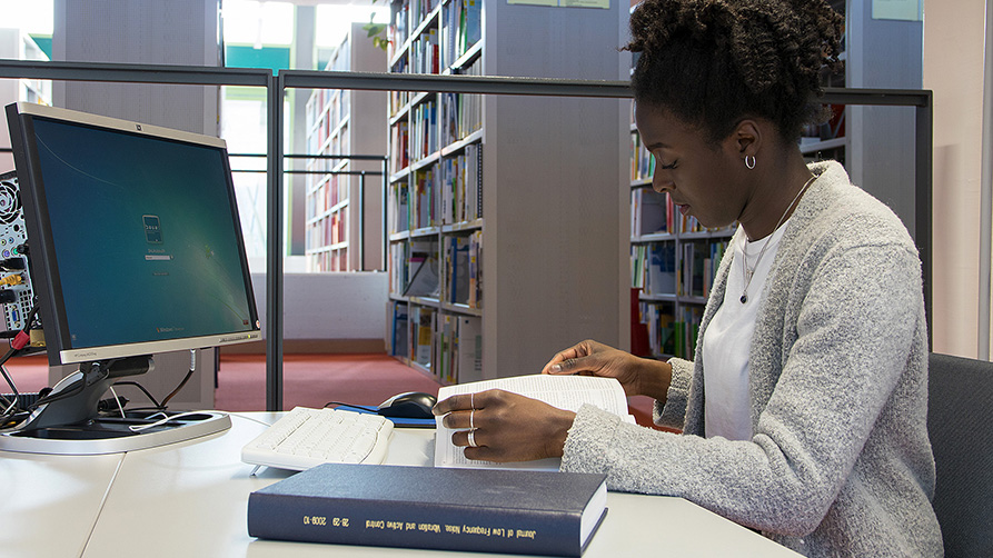 Woman reading a book in the library 