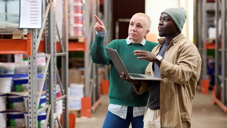 A woman and a man with a laptop carry out a risk assessment in a warehouse
